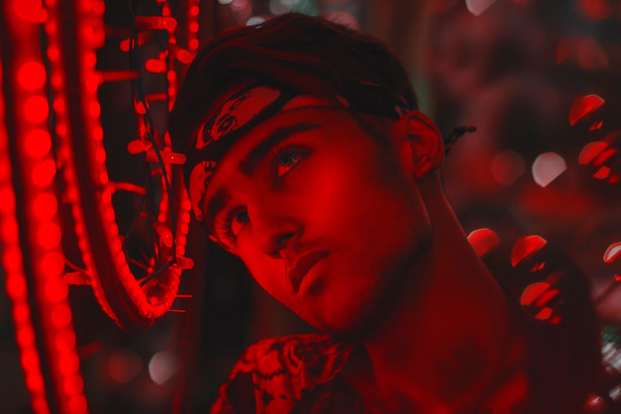 a striking portrait of a young man adorned with neon lights and vivid