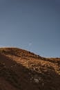 Brown Elevated Land Under Blue Sky