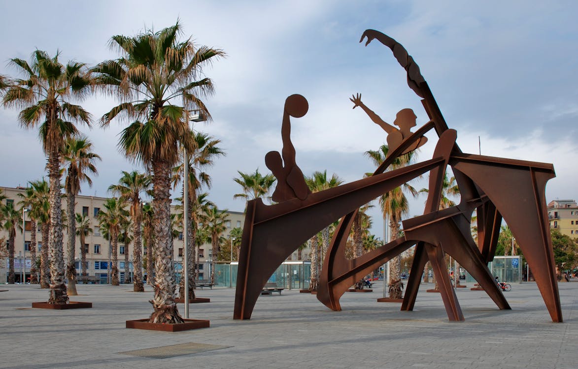 Brown Steel Sculpture of Sports Near Green and Brown Tree