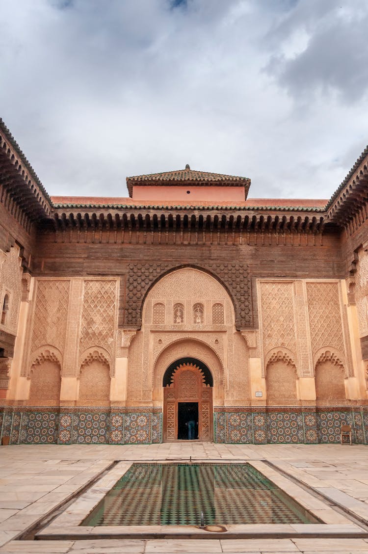 Old Moroccan Palace With Ornamental Walls And Marble Pool In Courtyard