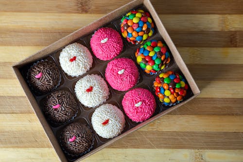Free Round Sweets in the Box on Wooden Surface Stock Photo