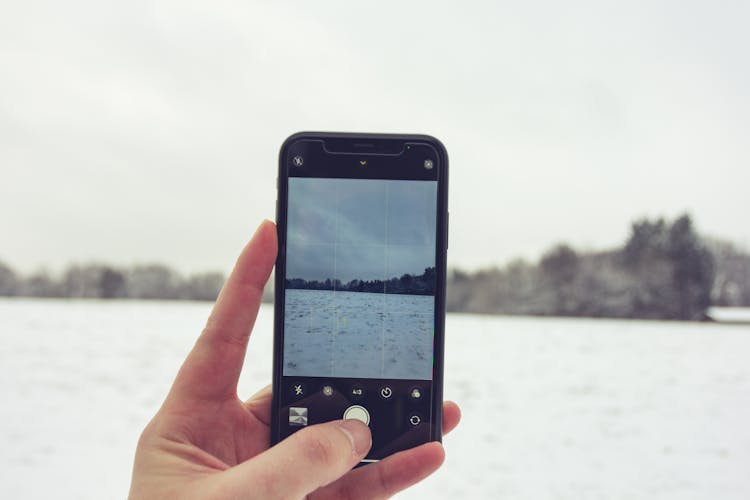 Crop Unrecognizable Person Taking Photo Of Vast Snowy Terrain