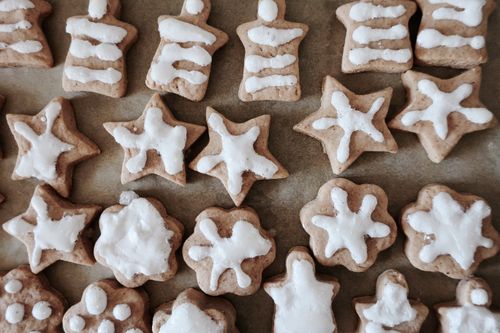 Free A close-up of assorted festive gingerbread cookies decorated with white icing in various holiday shapes. Stock Photo