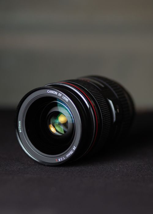 Free Optical lens of modern digital photo camera placed on table against dark background in studio Stock Photo