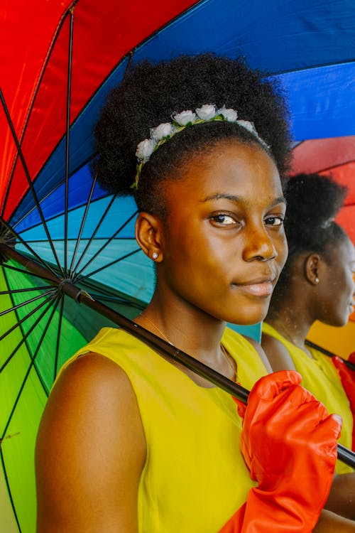 A Woman Holding a Rainbow Themed Umbrella