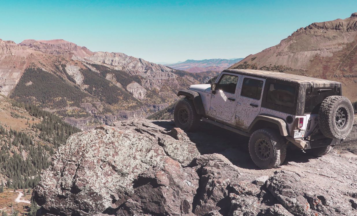 Car Driving Over Rocks An Off Road Vehicle on a Natural Rock Formation · Free Stock Photo
