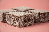 Close-up of scrumptious lamington cakes with desiccated coconut on a pink background.