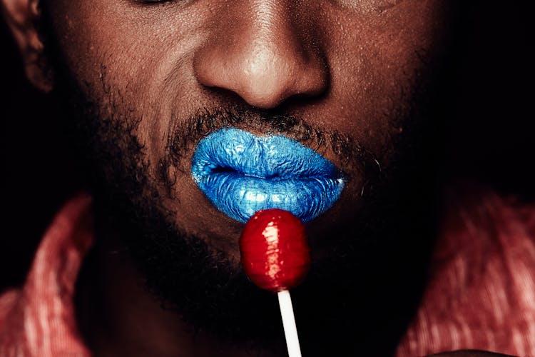 A Man Holding A Red Lollipop