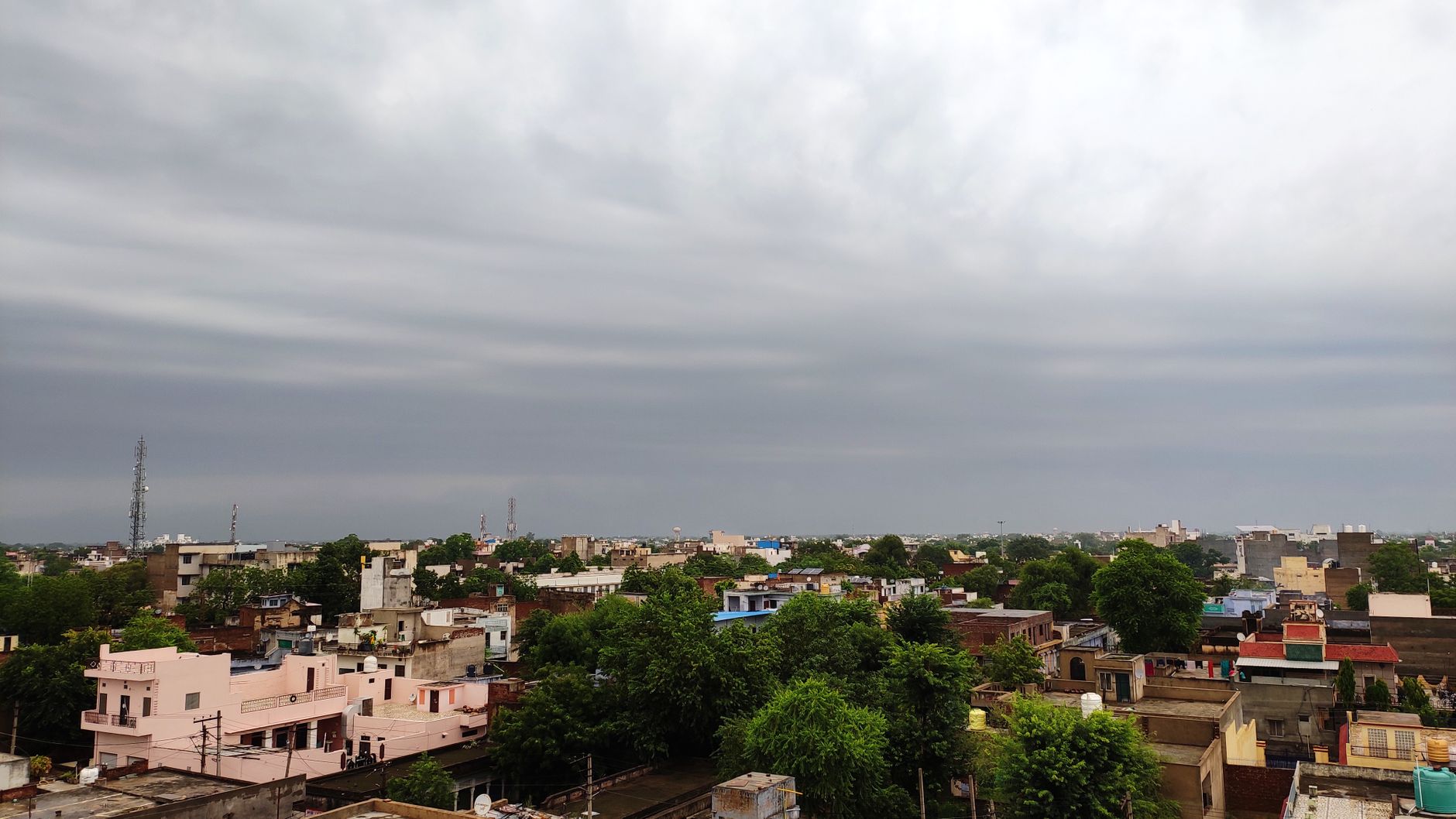 बारिश के बाद ढके हुए क्रिकेट मैदान के पास विश्लेषक लैपटॉप पर मौसम और रन गति देखते हुए