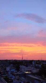 Stunning sunset view over urban landscape with vivid sky colors from a rooftop perspective.