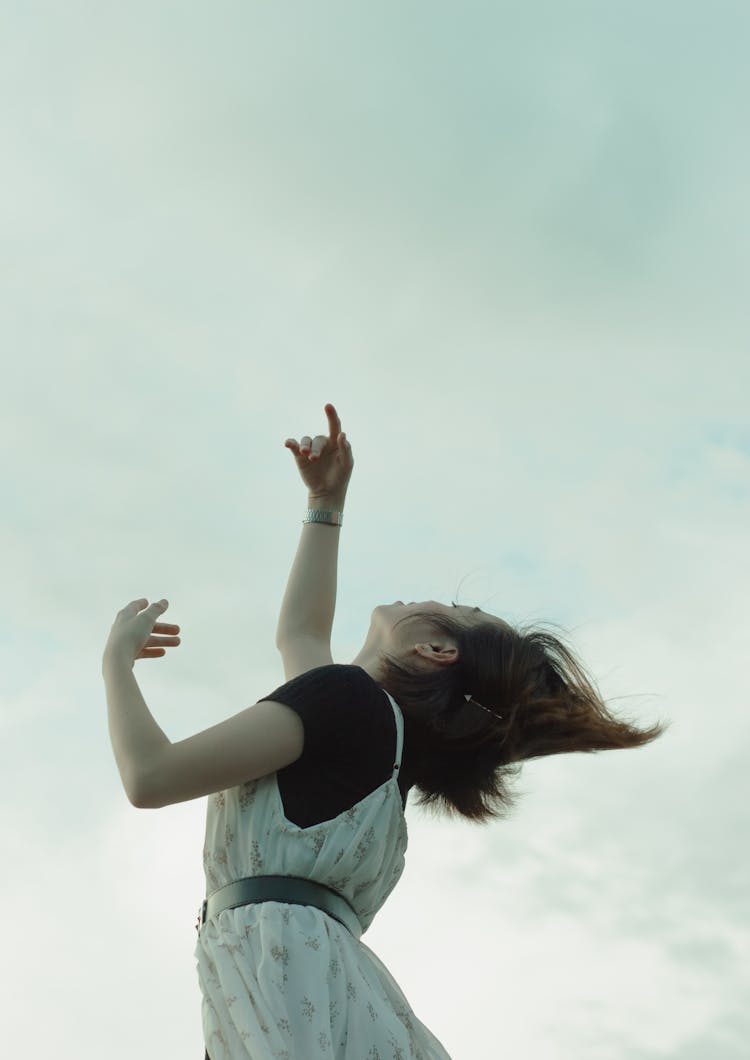 Woman Looking Up And Reaching Her Hands Up To The Sky 