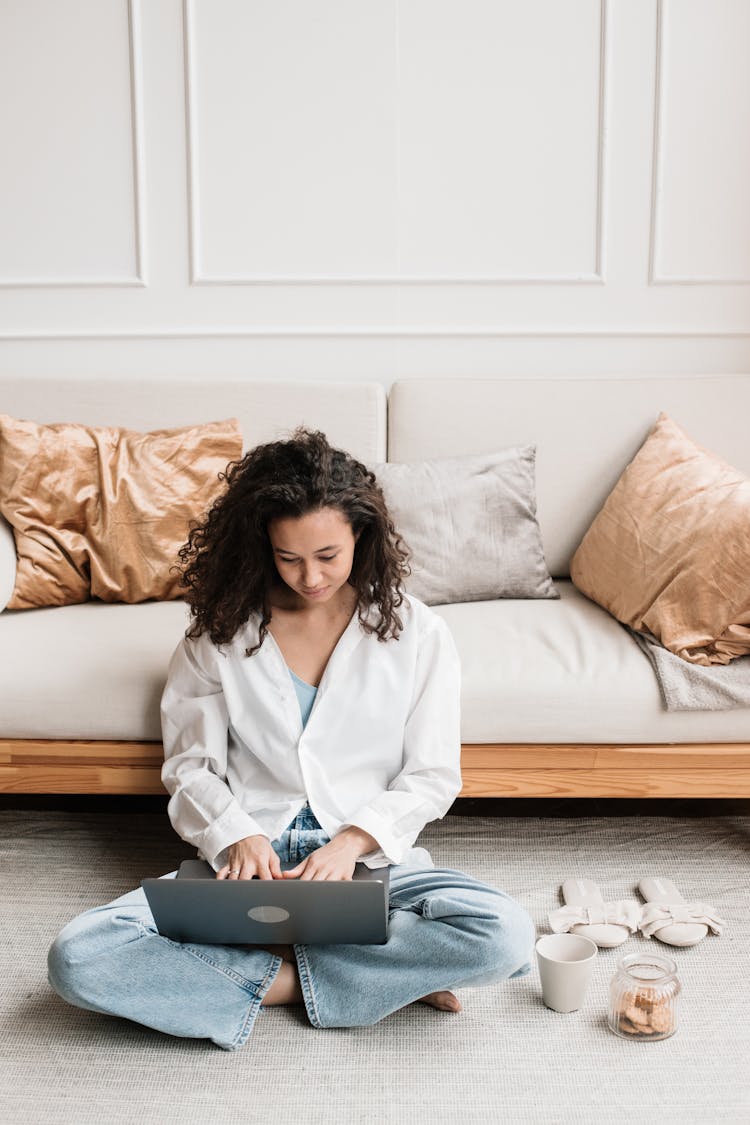 Woman Sitting On Floor Typing On Laptop 