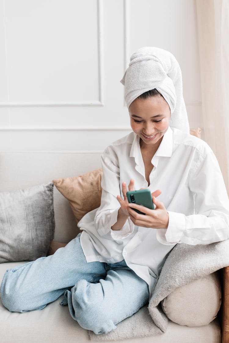 Woman Sitting On A Couch Using A Phone