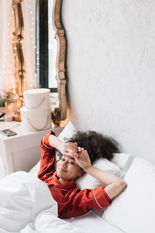 Free Woman in Red Pajama Lying on Bed Stock Photo