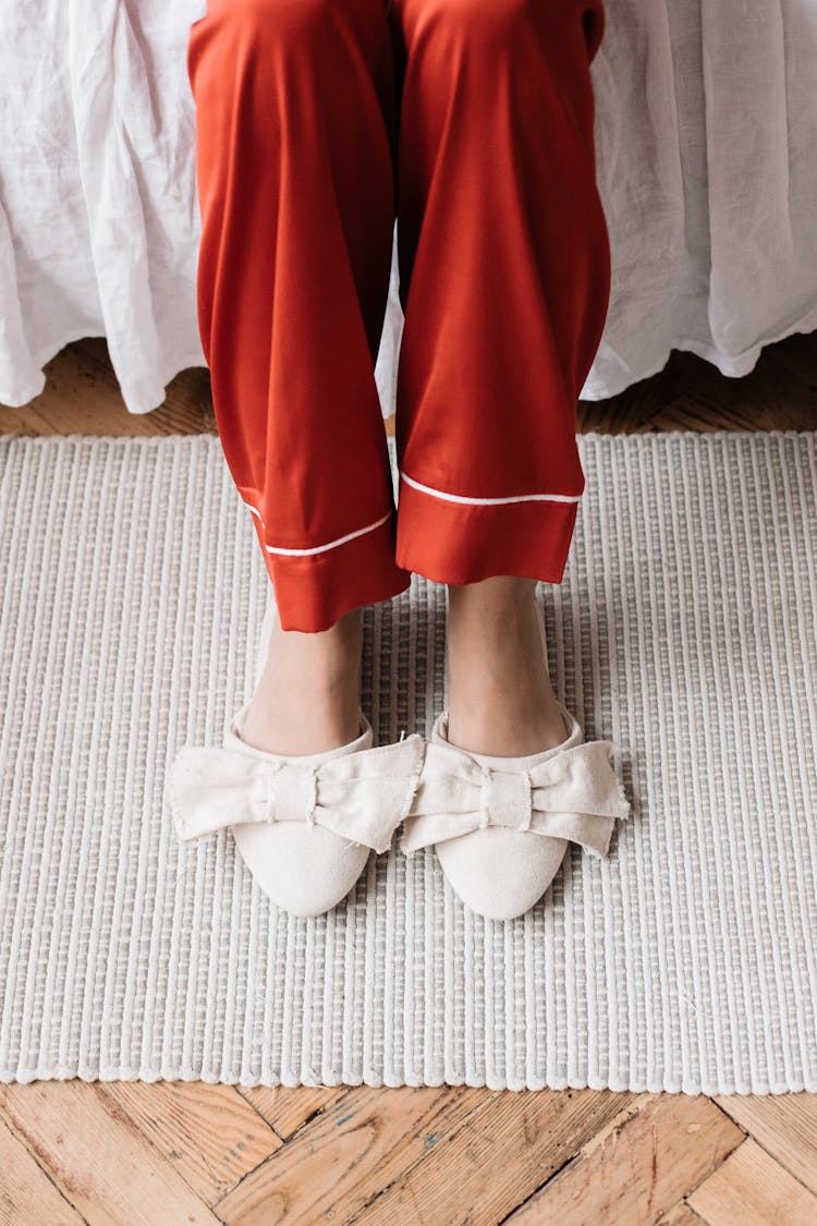 Woman In Red Pants Wearing White Slippers With Ribbons