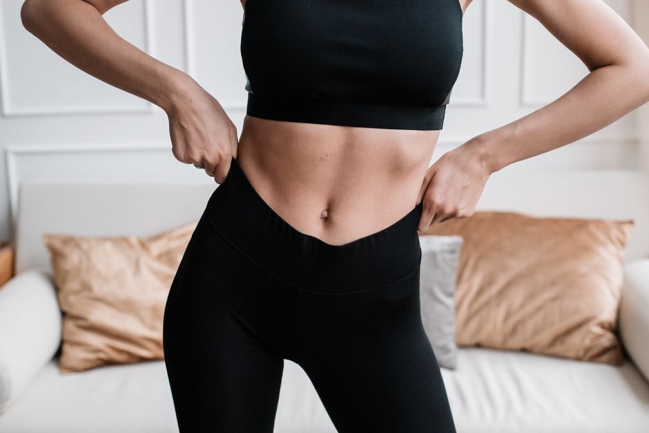 woman flat stomach mirror happy