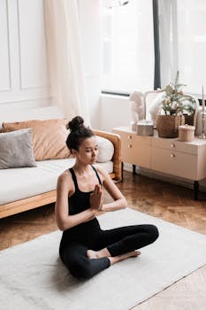 Woman practicing yoga in a serene living room setting, promoting wellness and relaxation.