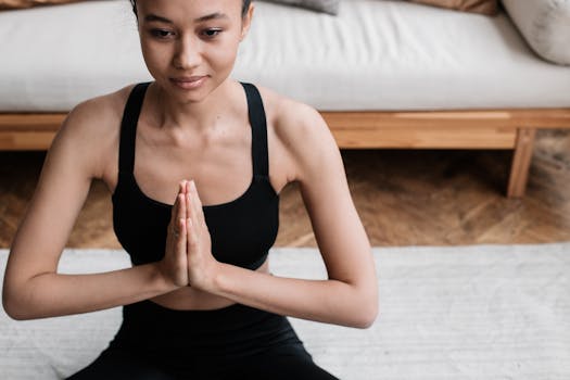 A woman in activewear meditating indoors, embodying peace and relaxation.