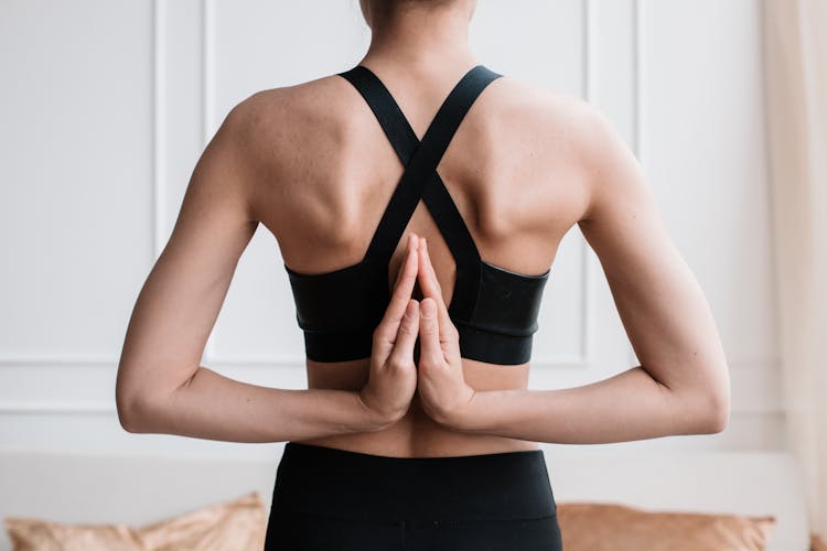 A Woman With Her Hands On Reverse Prayer Pose