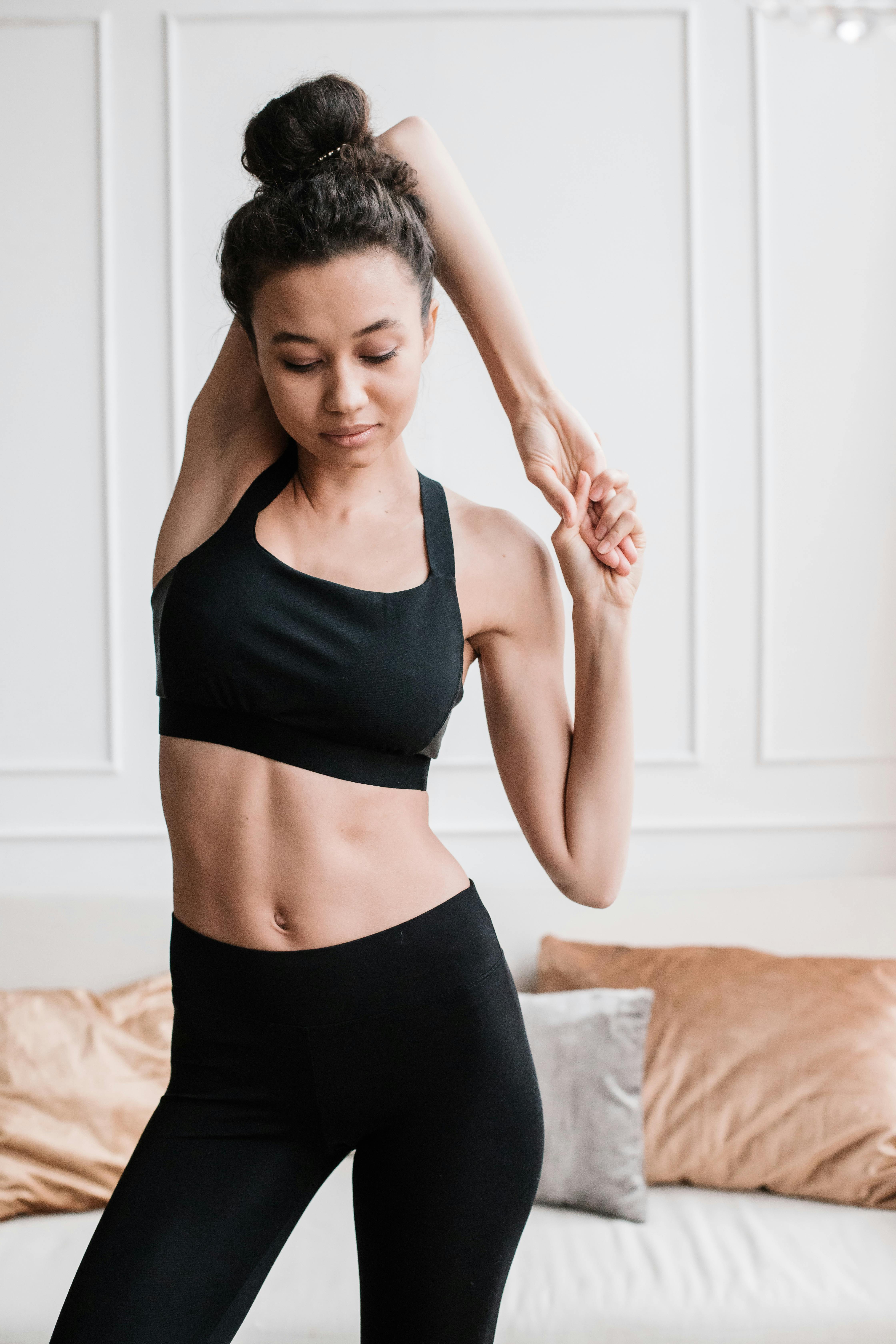 Woman in Black Sports Bra Stretching Her Arm · Free Stock Photo