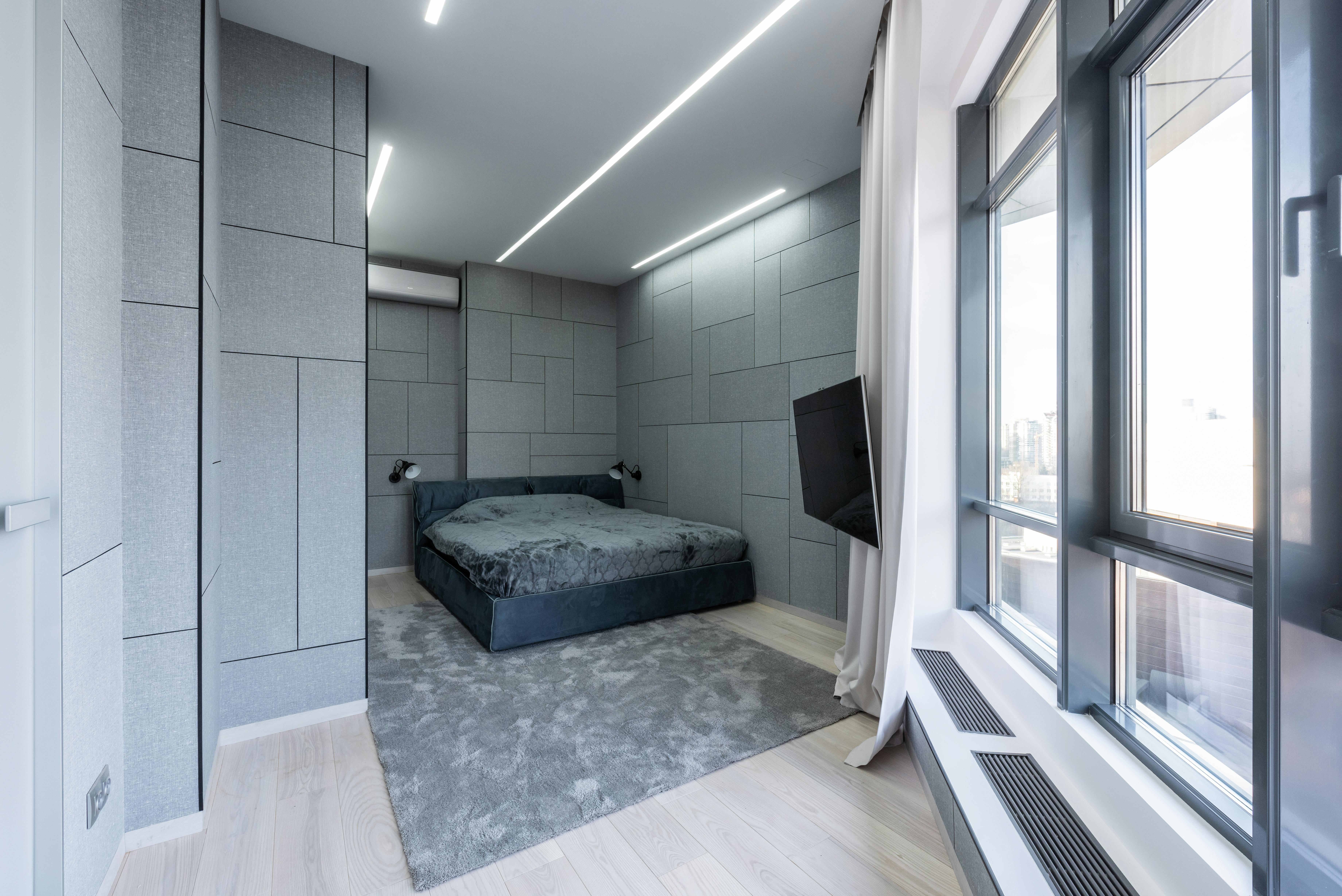 bedroom interior with tv and window near bed on carpet