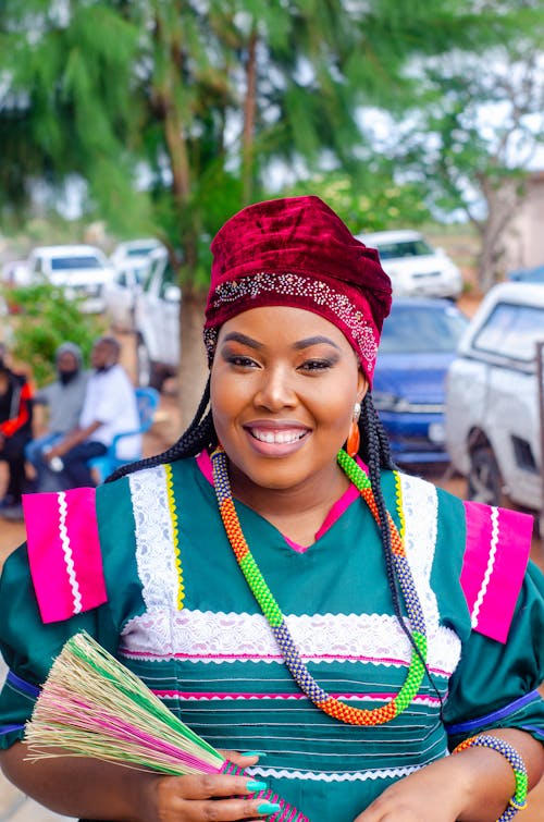 Free Smiling black woman in traditional clothes standing on street Stock Photo