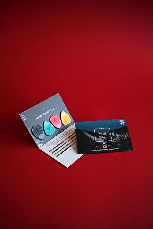 Photo of Cards with Guitar Picks on a Red Surface