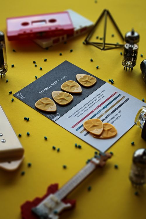 Free Guitar picks and accessories arranged on a vibrant yellow surface. Stock Photo