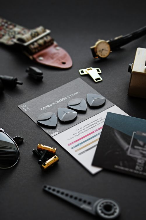 Free A display of guitar accessories including picks, packaging, and miscellaneous items on a dark background. Stock Photo