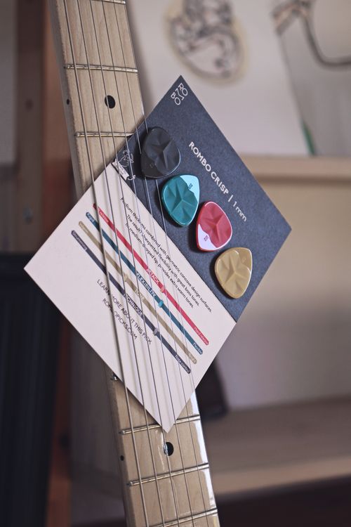 Free Close-up of Rombo guitar picks on an acoustic guitar with strings. Stock Photo