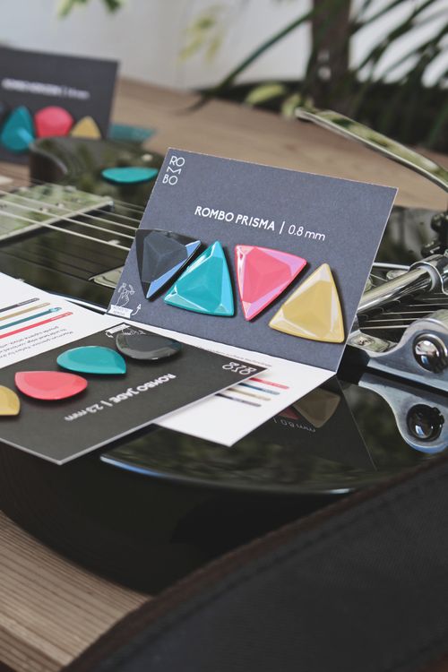Free Vibrant guitar picks displayed on acoustic guitar showcasing variety of designs. Stock Photo