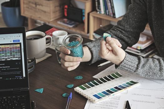 A creative workspace with a person selecting guitar picks from a colorful palette.