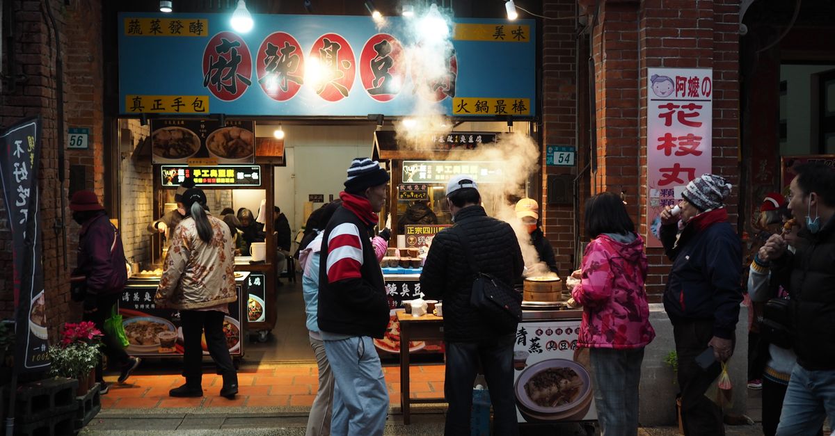 Korean street food market with colorful dishes and steam rising