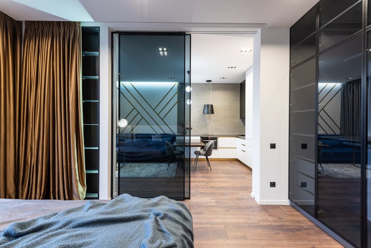 Modern Apartment Interior With Bed Near Glass Door To Kitchen