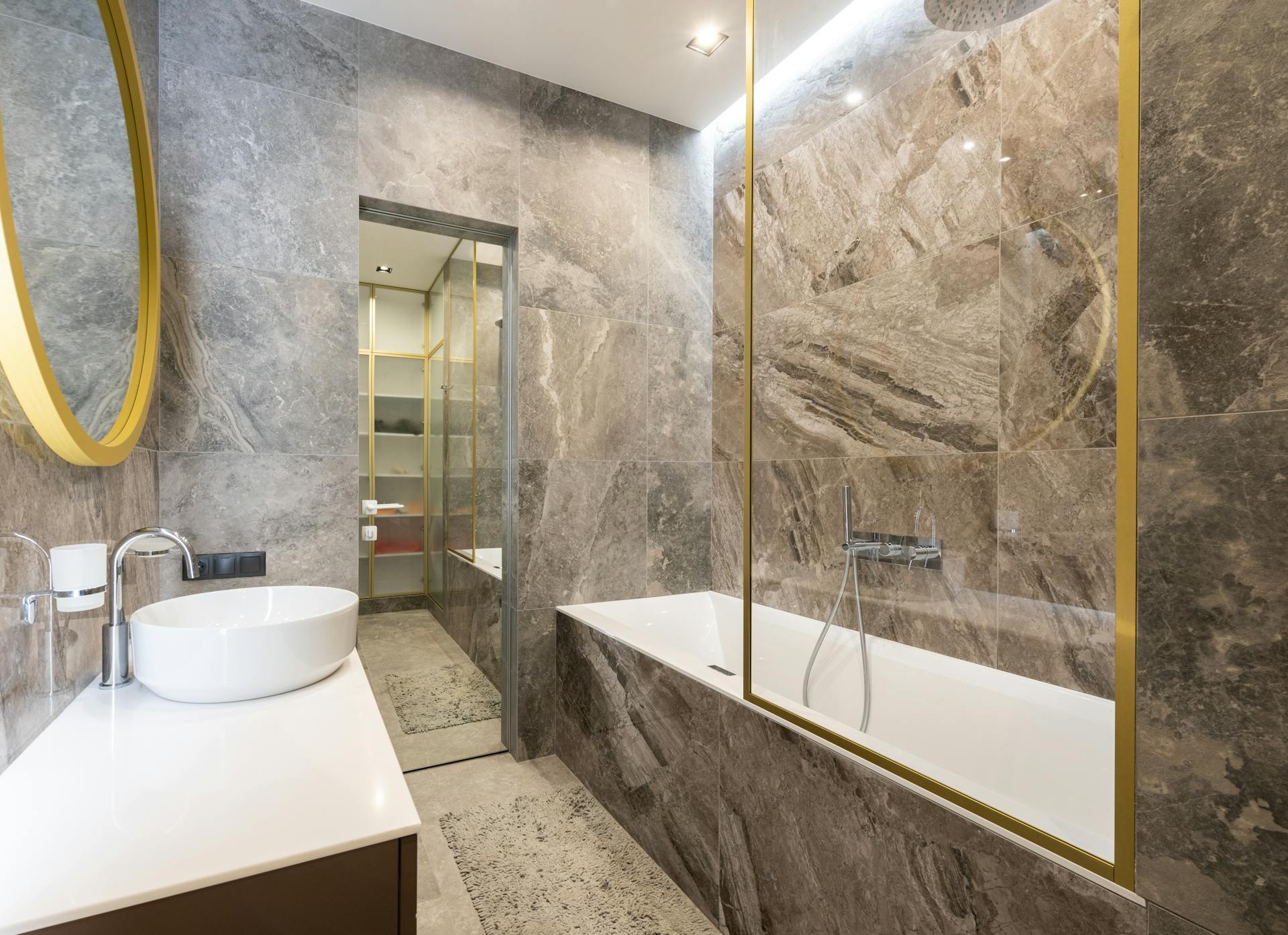 Modern bathroom with sink and faucet on counter near bath