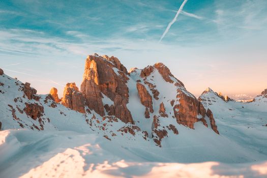 Stunning snow-covered mountains at dawn with a clear sky and warm hues, ideal for winter landscapes.