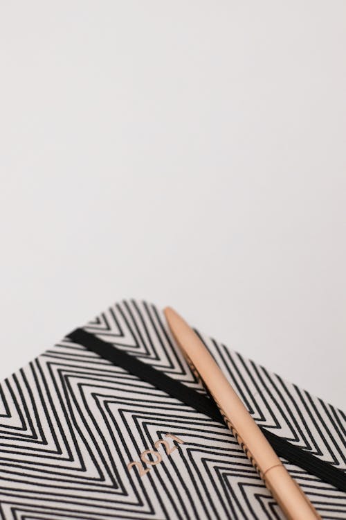Free A Zigzag Patterned 2021 Notebook and a Pen Stock Photo