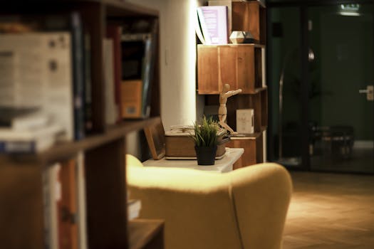 Modern interior view with a cozy armchair, bookshelf, and wooden decor.