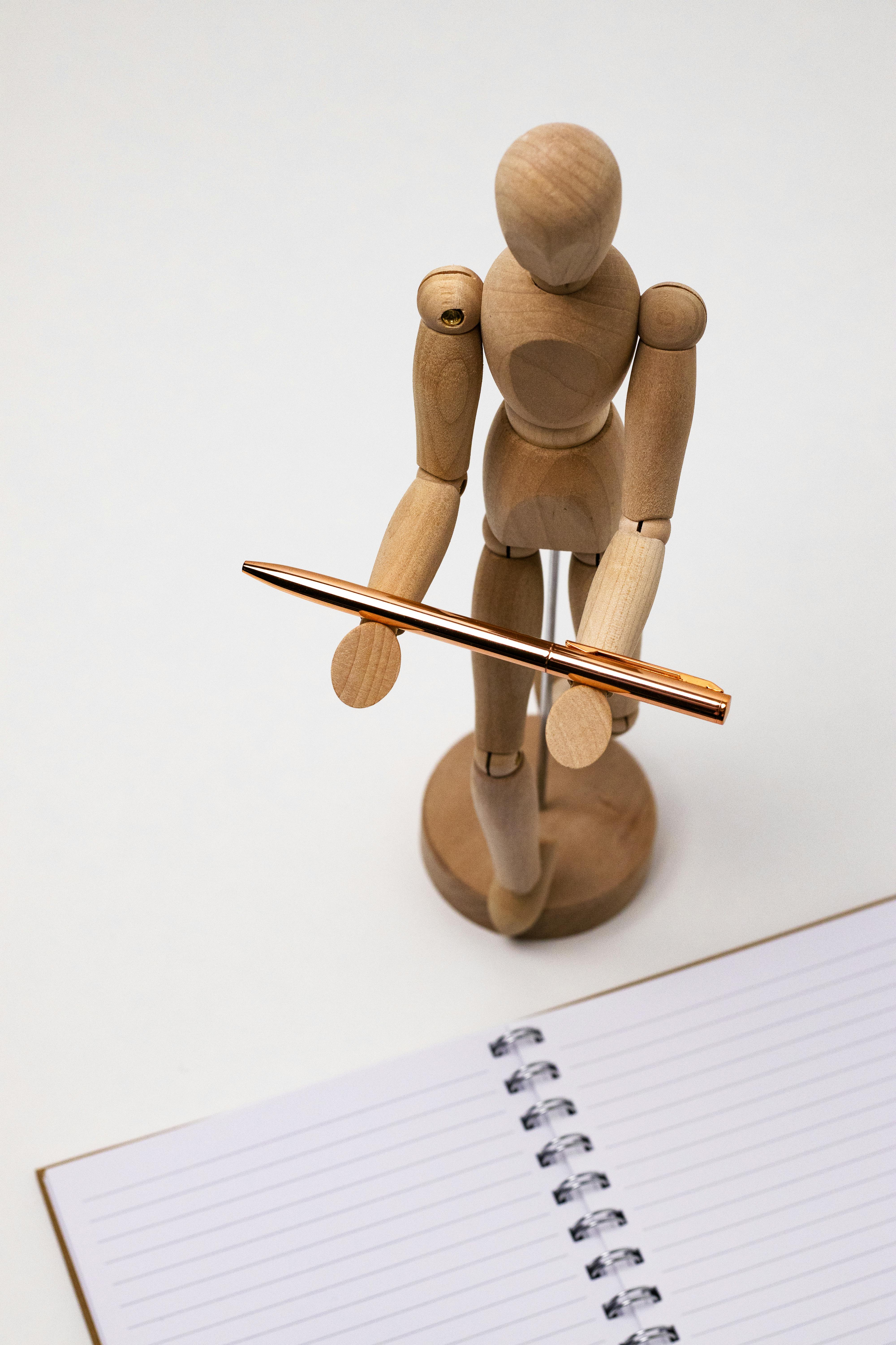 mannequin holding a bronze pen