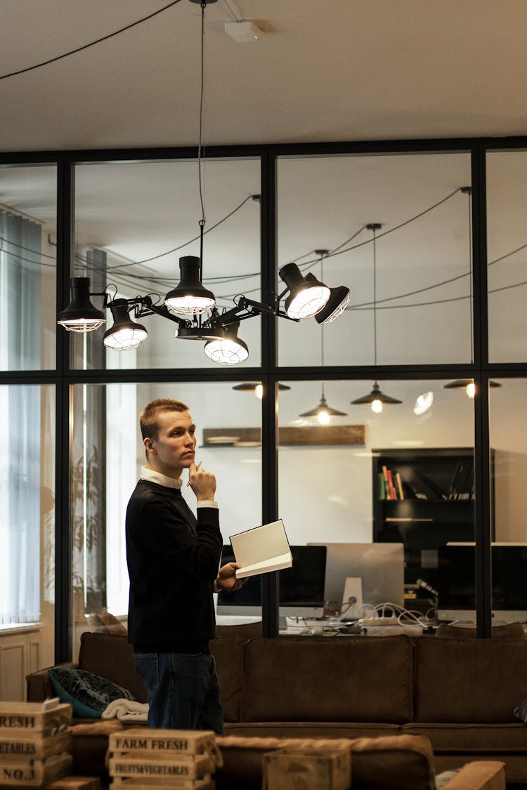 Man Holding A Notebook Walking Inside The Office