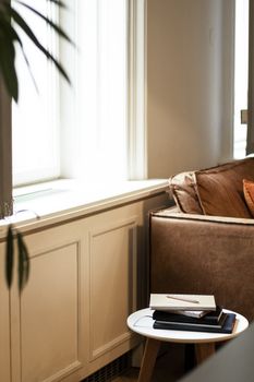 A serene living room interior featuring a cozy sofa and a small coffee table by the window.