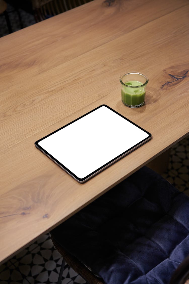 Tablet On Table Near Glass With Drink