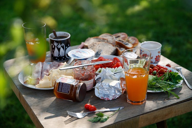 A Wooden Table With Foods And Drinks