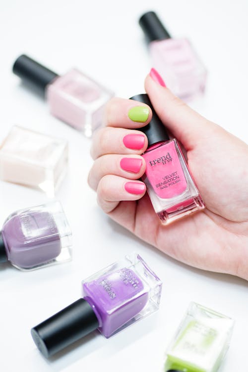 Free A Person Holding a Bottle of Nail Polish Stock Photo