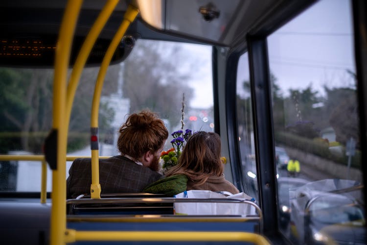 Back View Of A Couple Sitting Inside A Bus