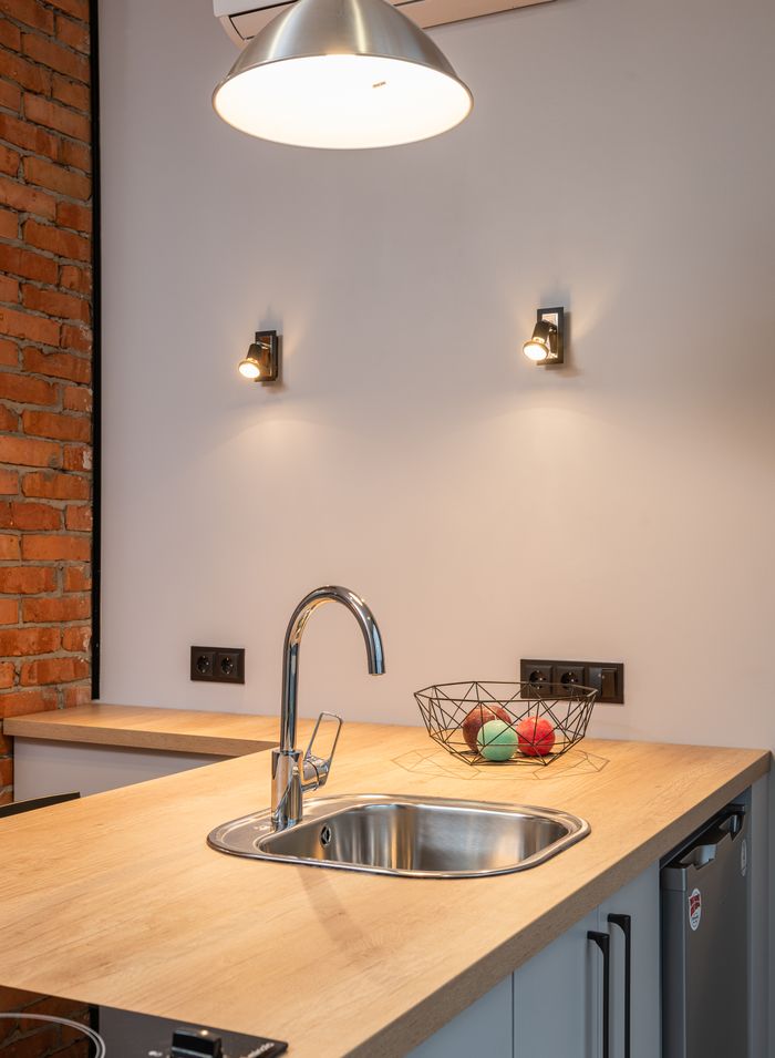 Steel kitchen sink with wall-mounted tap