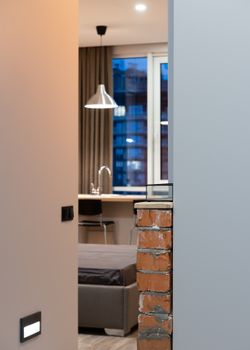 Interior of contemporary apartment in beige color with small kitchen room connecting with bedroom
