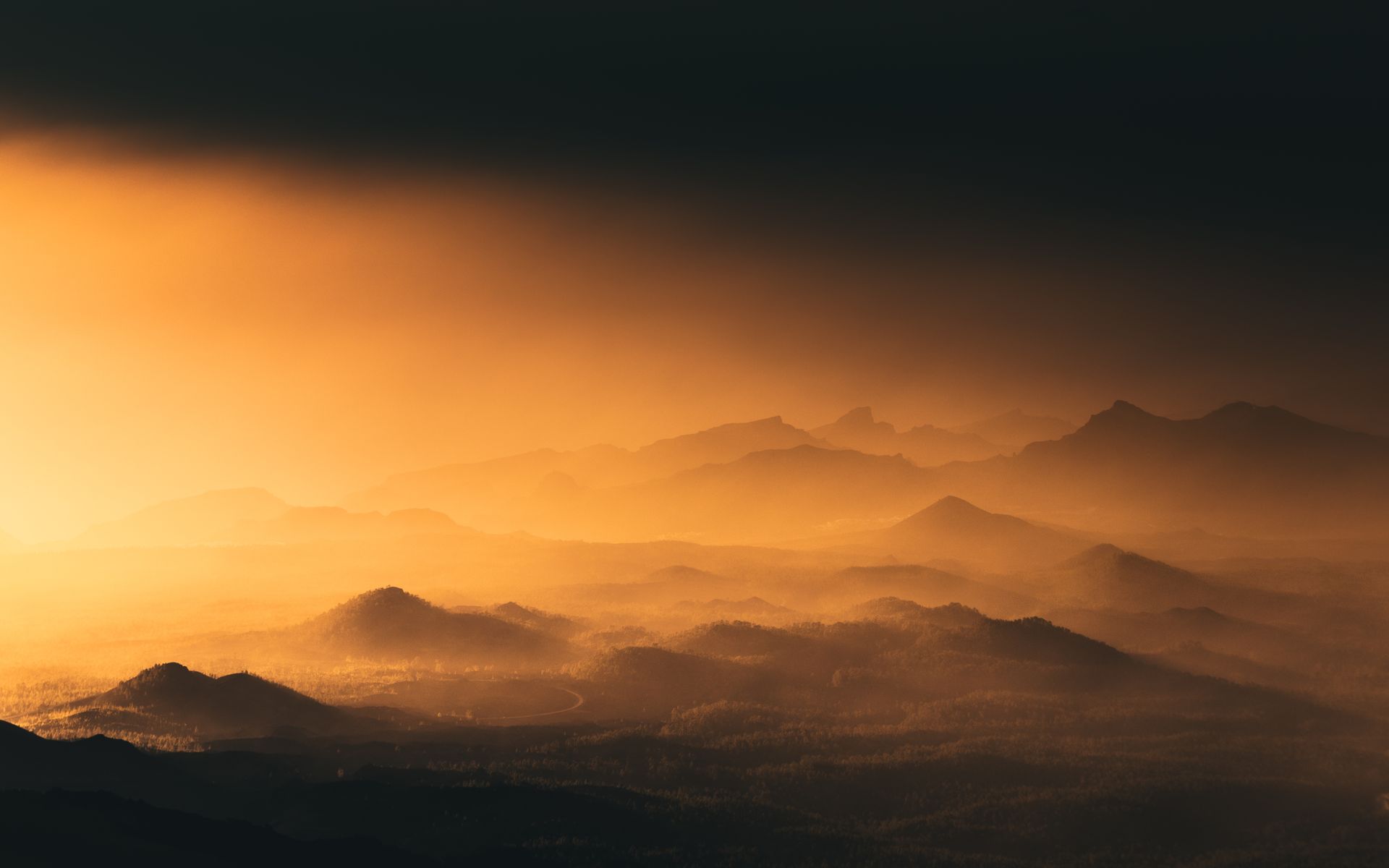 Montañas silueteadas bajo un atardecer dramático
