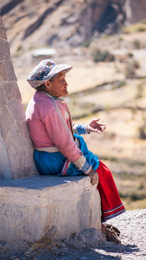 Elderly Woman Sitting on Concrete Bench