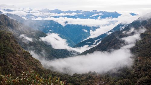 Free Breathtaking view of a mountainous valley shrouded in clouds and fog, providing a stunning scenic panorama. Stock Photo